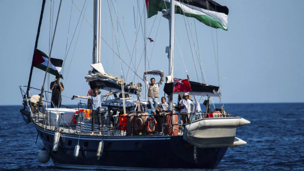 Activists waving Palestinian flags from Madleen board.
